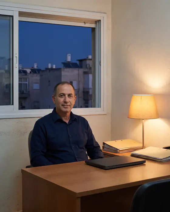 בעל הסוכנות ליד שולחן העבודה, לאור מנורה חמה